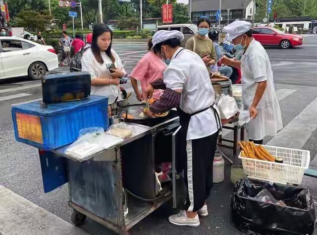 摊位前，一个刚刚迈出创业第一步的姑娘，手忙脚乱地翻炒着锅里的米饭。火候掌握得不够