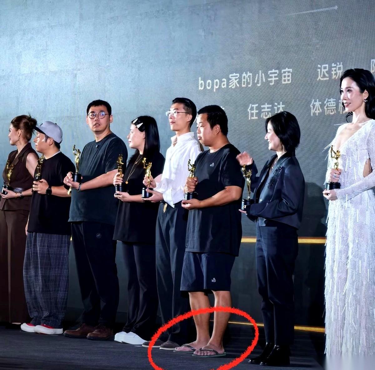 一帮大佬西装革履，人模狗样地坐在那儿。结果一个哥们儿，穿着人字拖大裤衩子就上