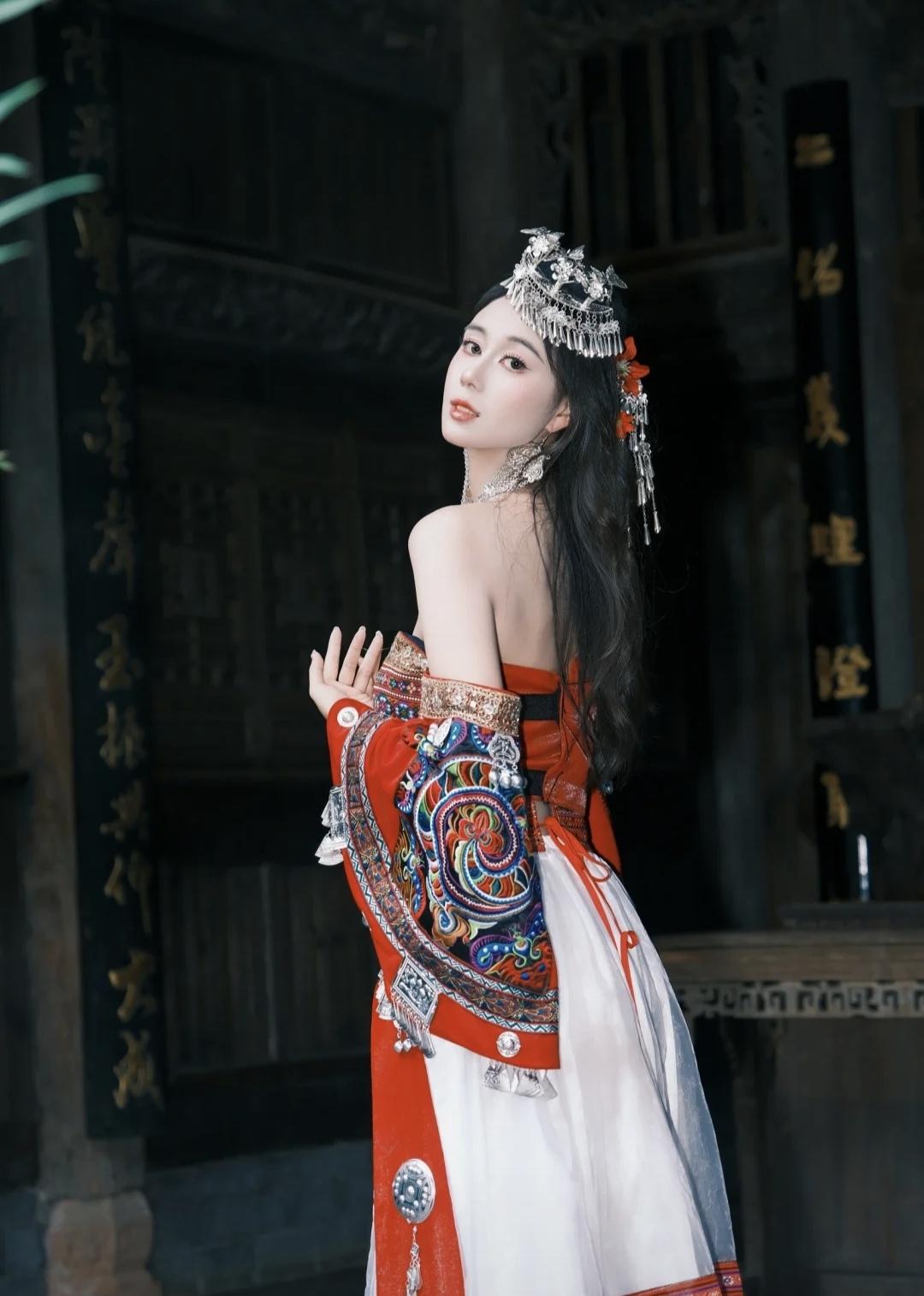 奚梦瑶的妹妹何超欣又去苗寨玩了，在下司古镇穿戴一身红色苗族服饰，古色古香，