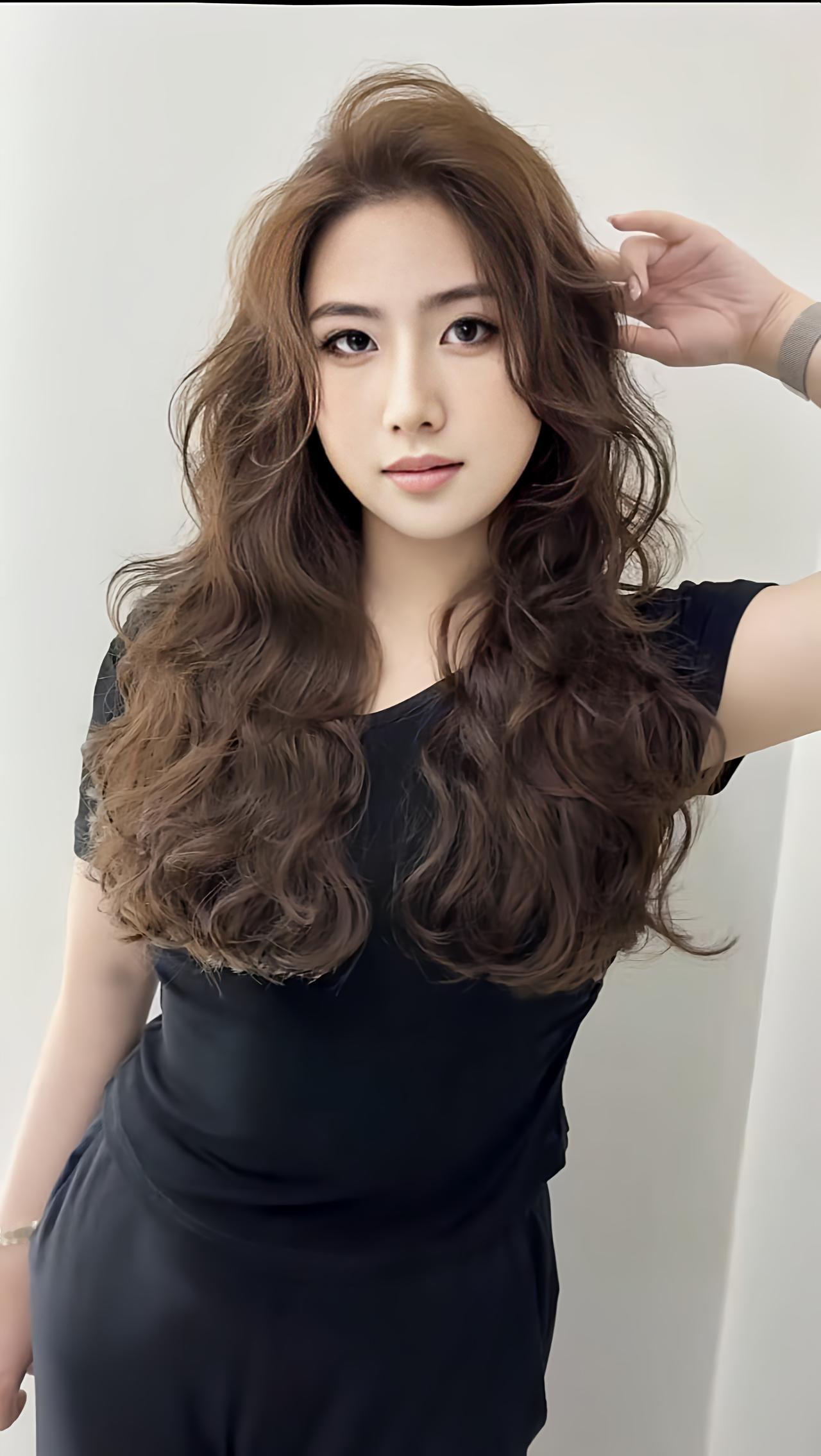 一头蓬松卷发解锁新的风格，焦糖棕的色调揉着暖调温柔，黑裙的简约衬得发丝更有层次感