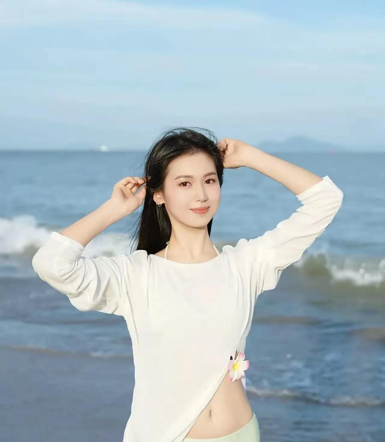 海边少女，轻抚发丝，微风拂面，阳光正好。好美好美海边活力少女海边度假少女海边