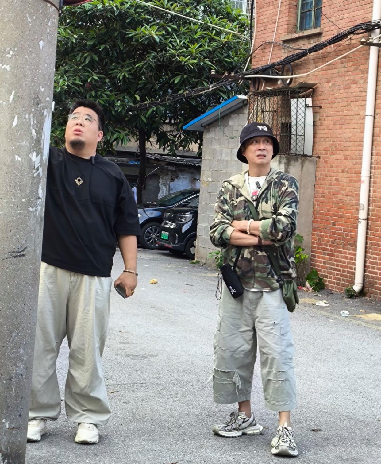吴镇宇下身穿乞丐裤、上身迷彩服、头戴黑色Y—3渔夫帽，现身湖南长沙一旧居民楼区，