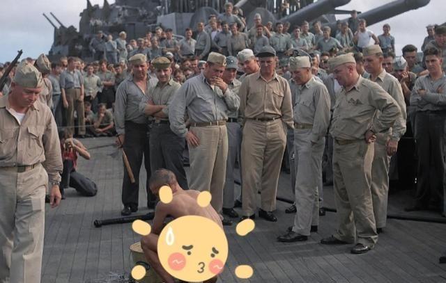 二战期间，美国大兵们在战列舰上，围观一名日本战俘洗澡。这名瘦弱的日本战俘被剃光了