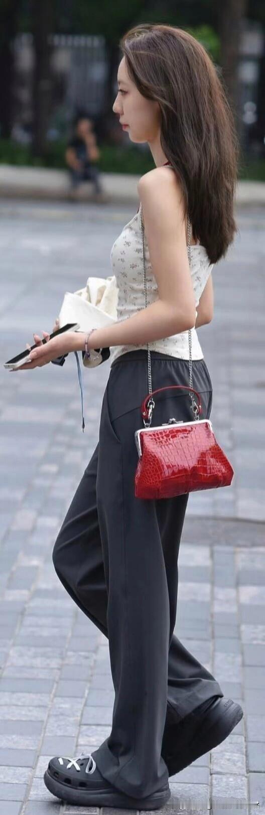 都市街头，简约白色上衣配黑色阔腿裤，再搭个红色手袋，时尚舒适感直接拉满。经典黑白