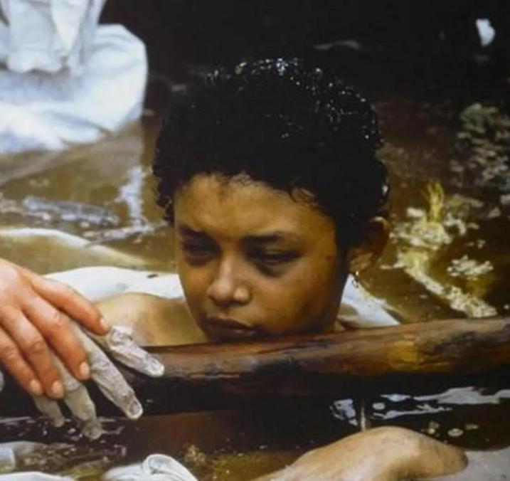 1985年，一张小女孩的照片传遍了世界。她半身浸在泥水里，只露出苍白的脸庞，一双