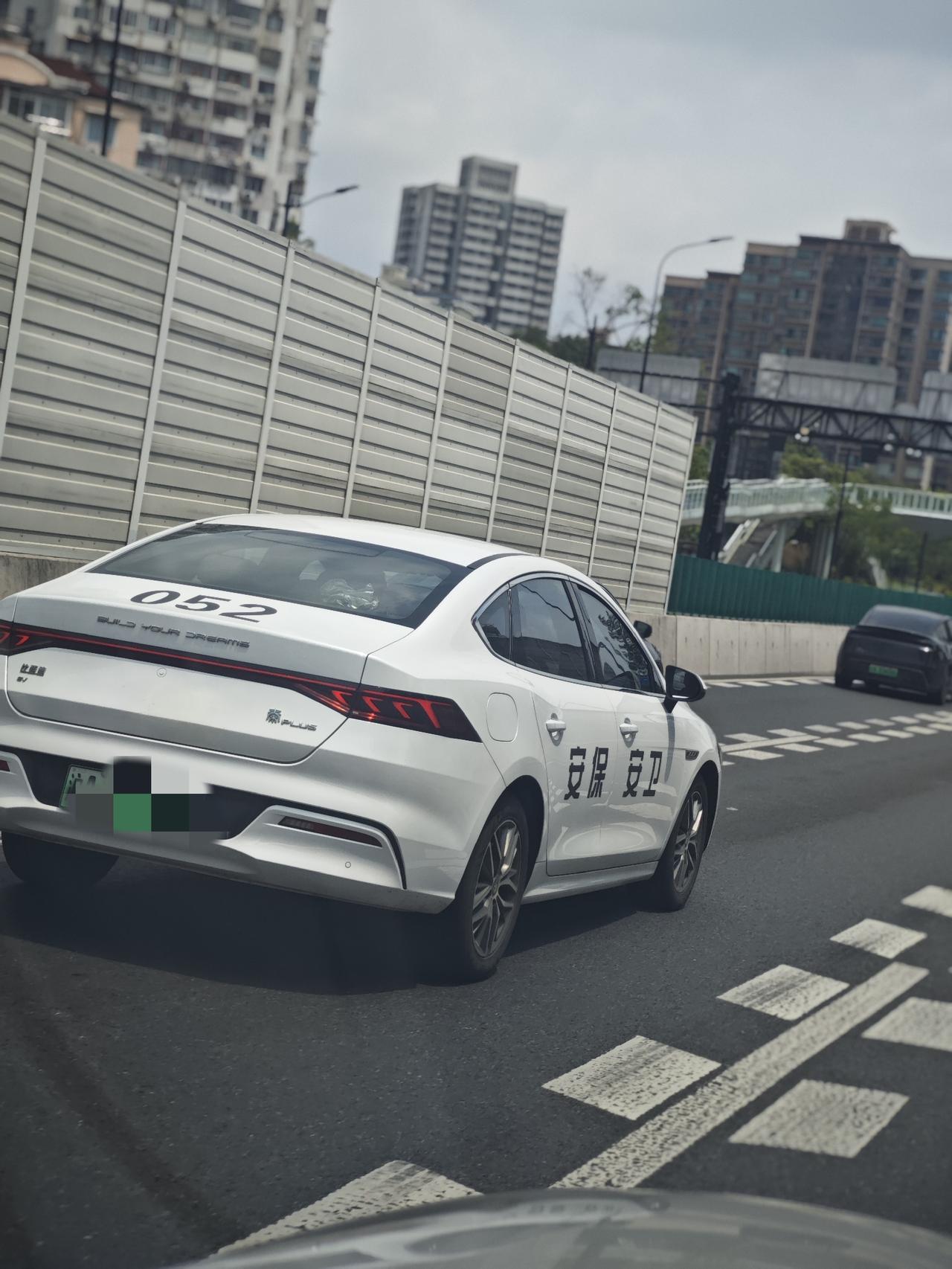 路上看到还有这样喷涂的车，右侧写着“安保安卫”，车后备箱盖上编着号码052，左