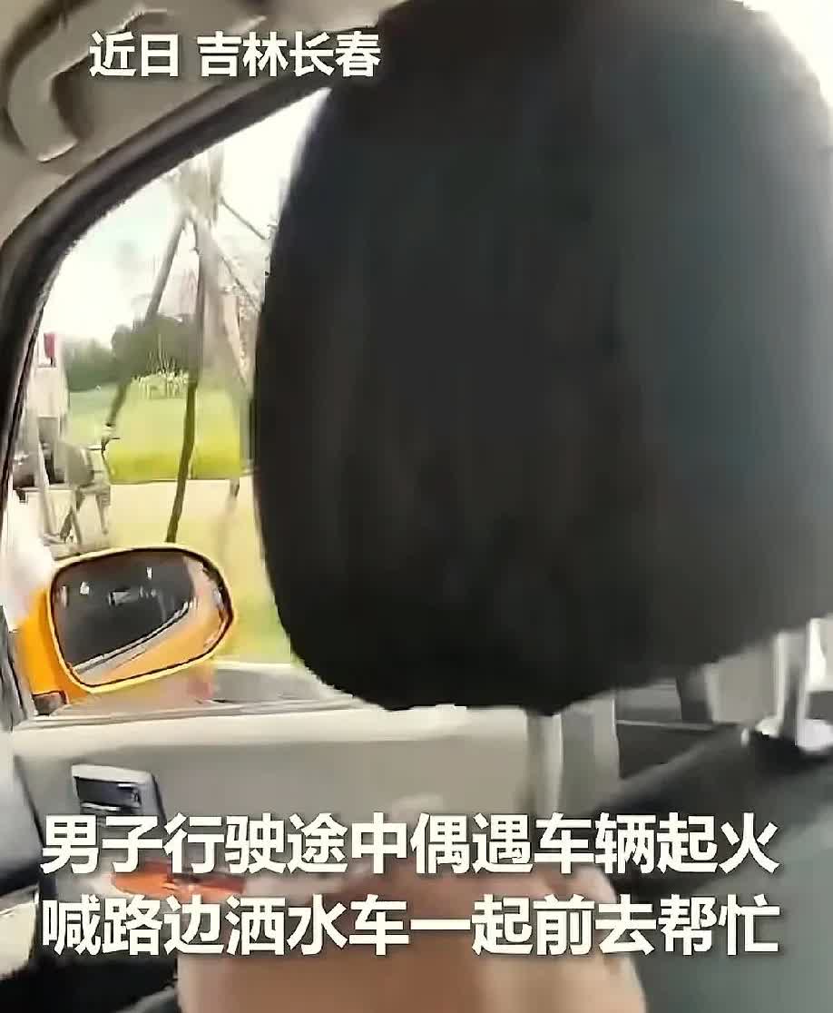 近日吉林长春，一名男子在行驶途中偶遇车辆起火，这时正好看见路边洒水车经过，赶忙大