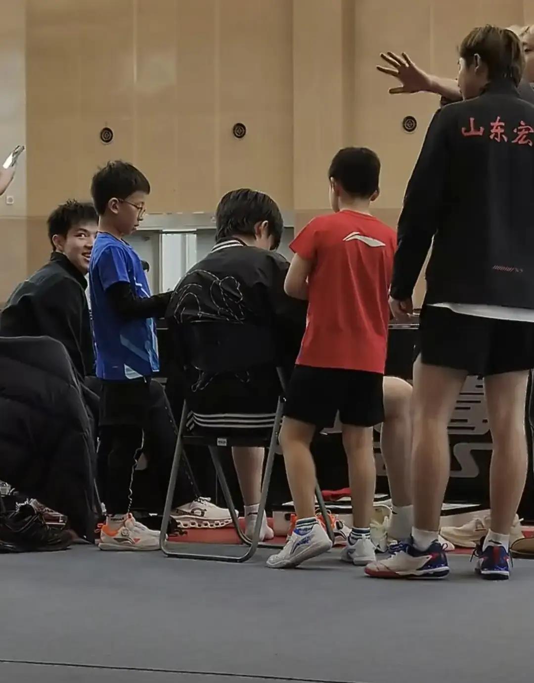 光脚签名！王楚钦把袜子踩黑上海交大体育馆昨天挤爆。冠军没穿鞋，蹲在地上给两