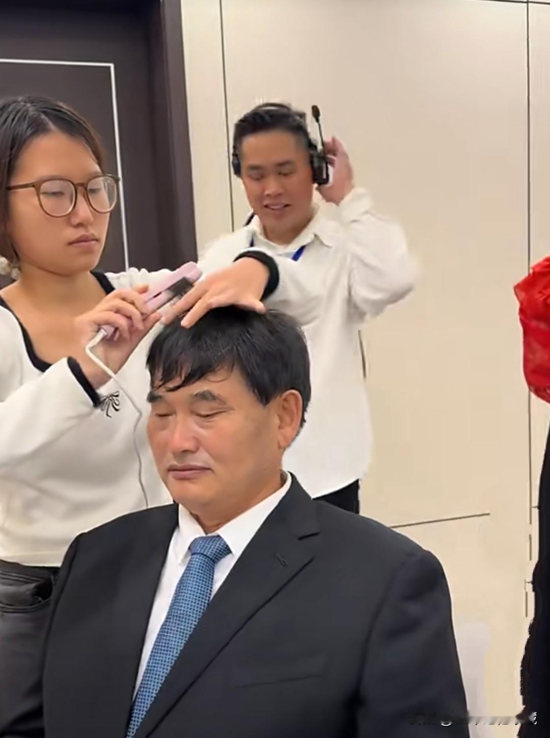 大衣哥朱之文在演出现场后台，发型师为他量身定做发型，以全新的面貌给观众留下最好的