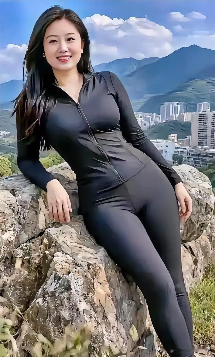黑衣贴身显张力，倚山石而坐。远眺城市与青山，笑容自信，于开阔天地间尽显健康活力。
