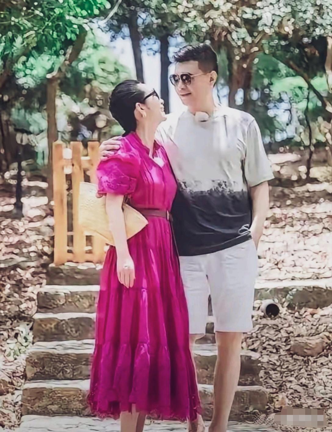 秦海璐一身玫红色连衣裙，被老公牵着手甜蜜的像个新媳妇。