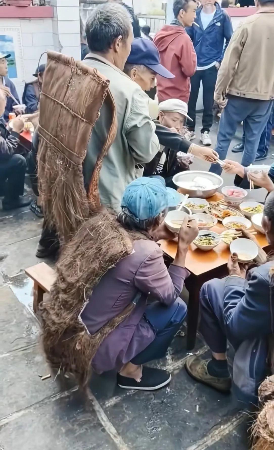 真想不到现代还能看见这个！乡下办席的一幕，几位大爷还披着老旧蓑衣，围坐在一起吃流