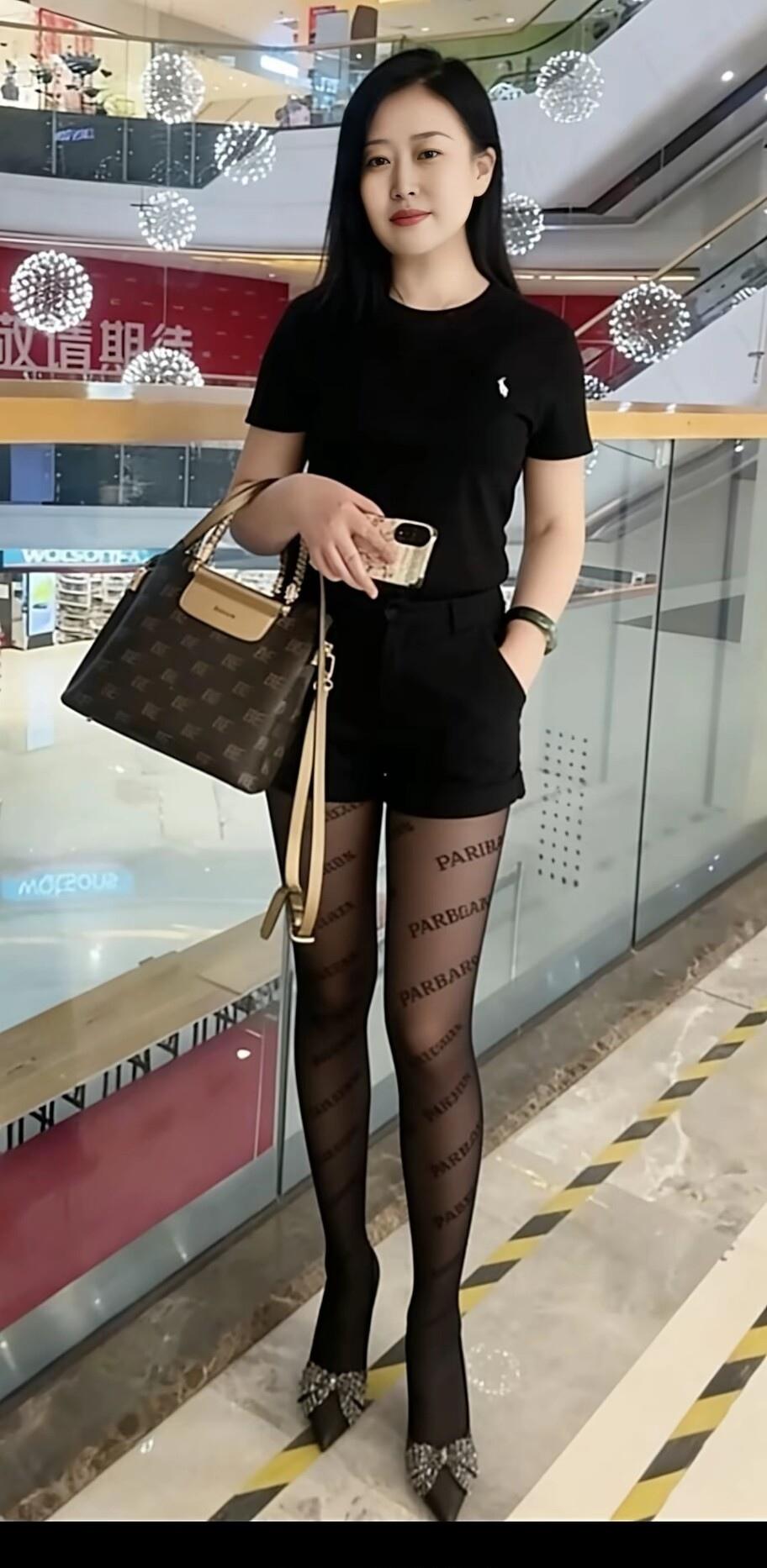 黑色短袖搭配透明印花丝袜，手提包点缀，都市女性风范！