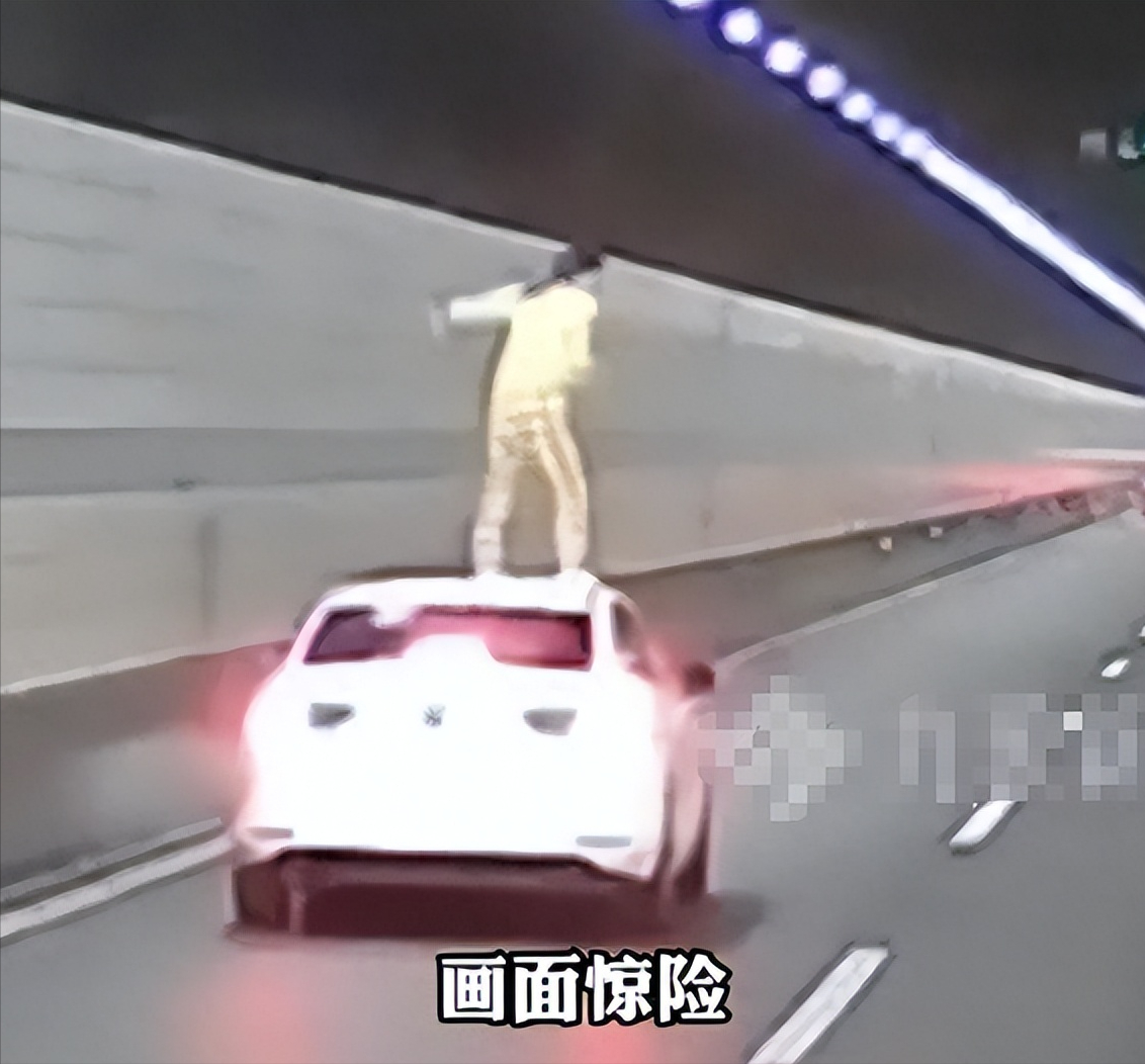 车子在隧道里正常开着，副驾女子突然爬出车窗、站上车顶、张开双臂——纵身一跳！后方大货车紧急避让，车身