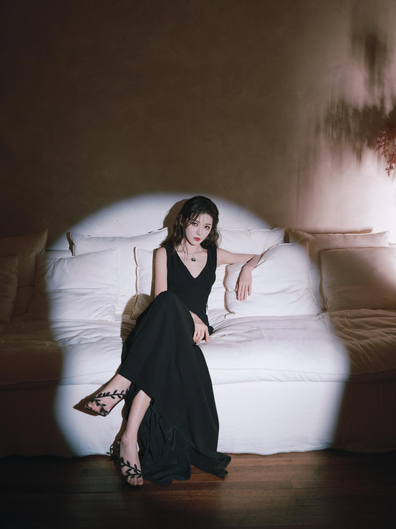 黑裙美人卧躺，光影交错，尽显优雅与神秘。张予曦！