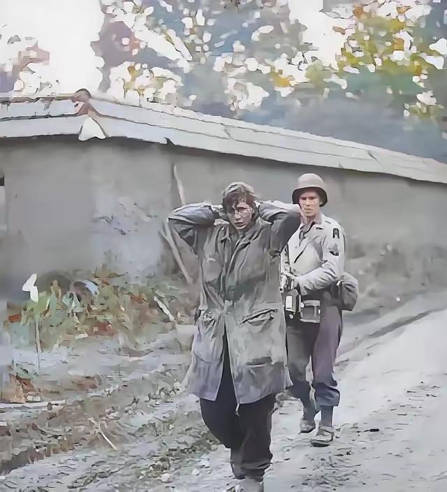 1945年，美军士兵正在押解德军女战俘。这名女兵身高足有1米75，留着利落短发，