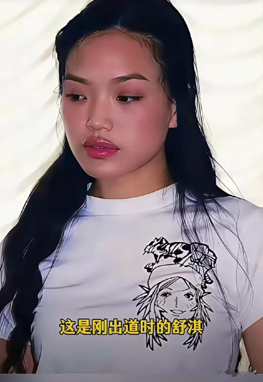 这是刚出道时的舒淇的一张老照片一头湿漉漉的长发，简单的白T恤透着青涩，她眼神低