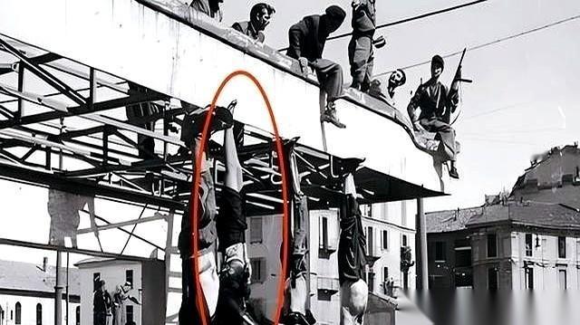 他们被倒吊在米兰的广场上，像两块破布。那个女人的裙子滑了下来，身体就那么暴露在成