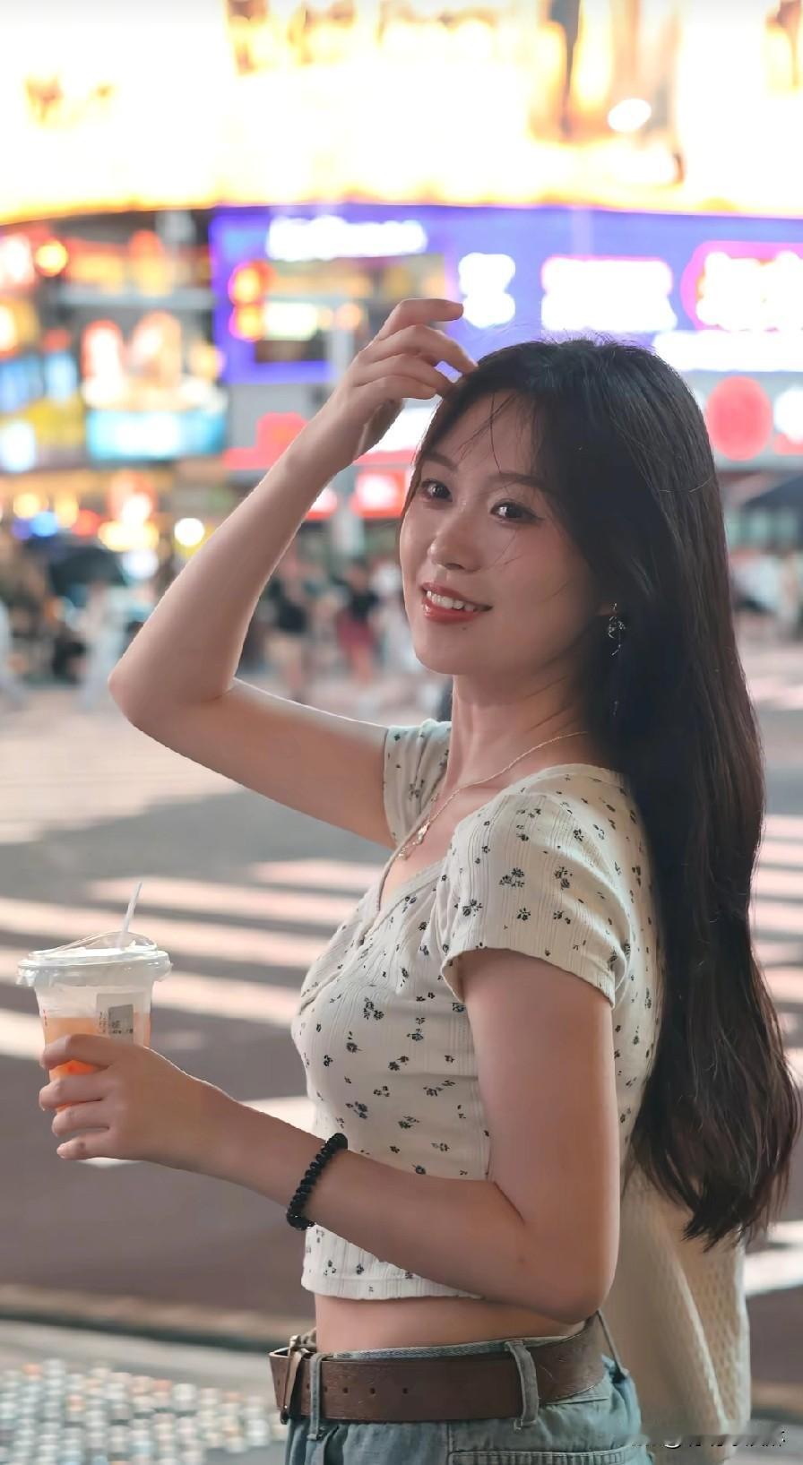 夜晚街头的甜美少女，手拿奶茶，微笑如花