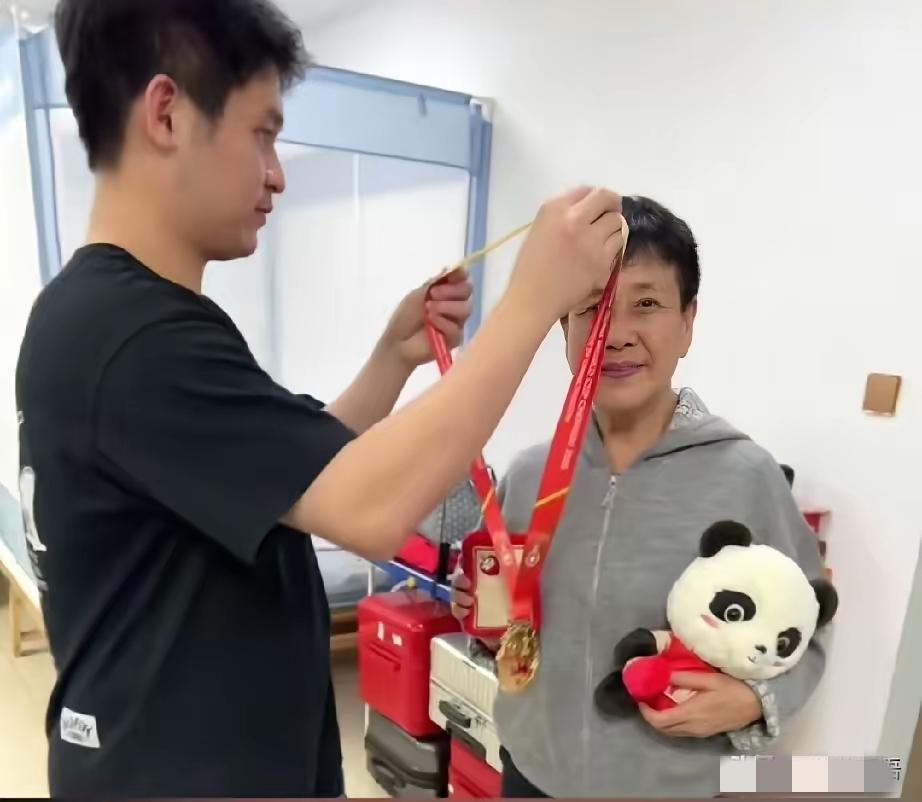 林诗栋真是宝藏男孩，回到海南就去看望恩师，把自己的混团金牌给恩师戴上，还细心的为