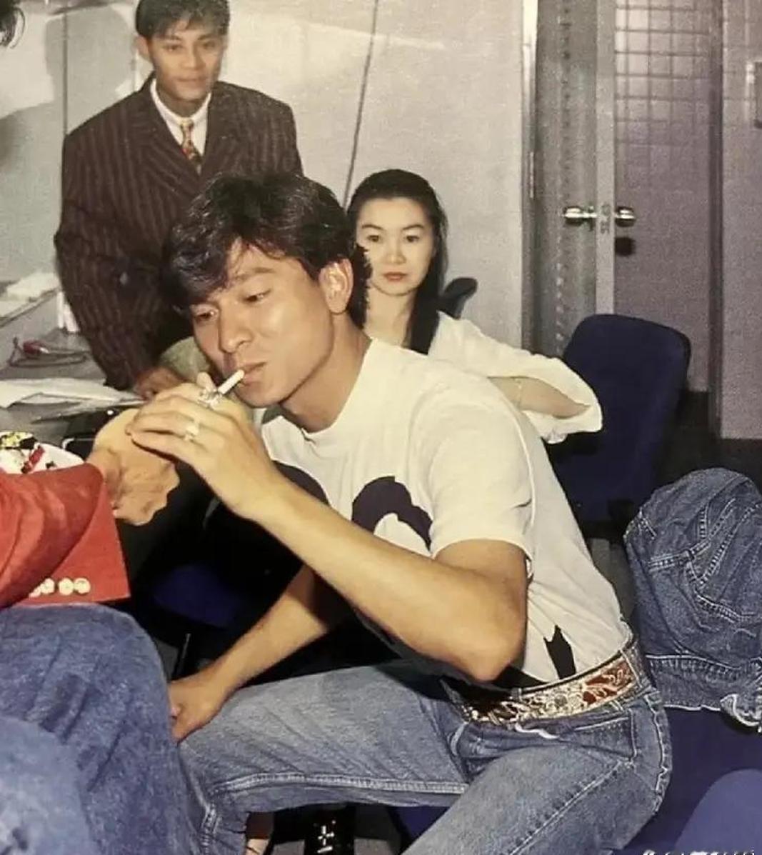 90年代，活动后台，刘德华与莫少聪、张曼玉等人的一张留影，当时一位友人正在给刘德华点烟。