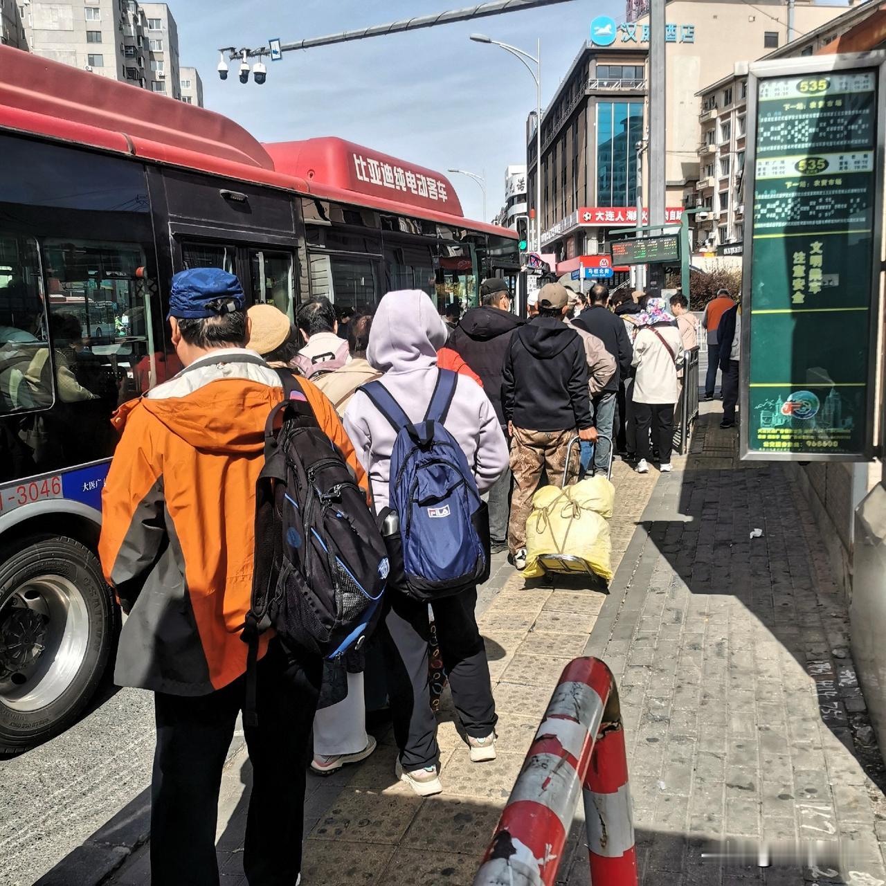 平峰期，公交车站数十人在排长队，您信吗？干啥去？这个车站是大连公交535马栏