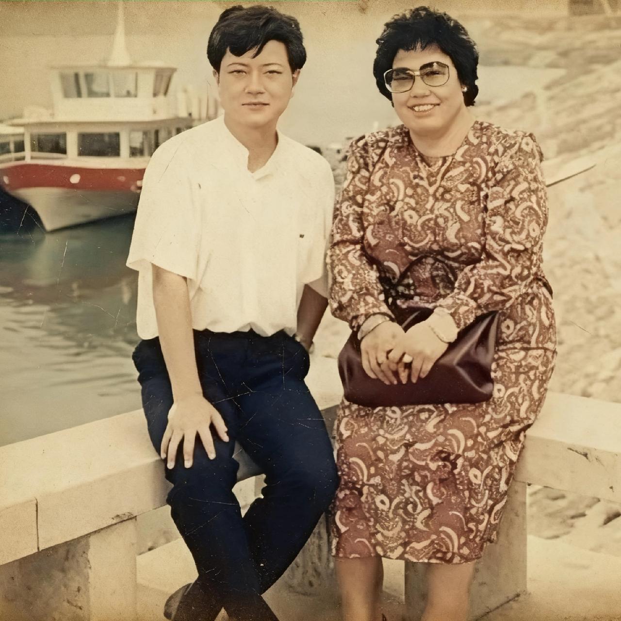 90年代，陈丽华年轻时的真实模样，照片中的陈丽华和友人坐在石凳上，手里拿着一个皮