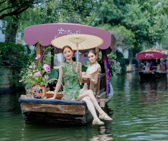 最近佟丽娅亮相黎里古镇坐游船，她这次特意选了一件绿色的旗袍，看上去很有大家闺秀的
