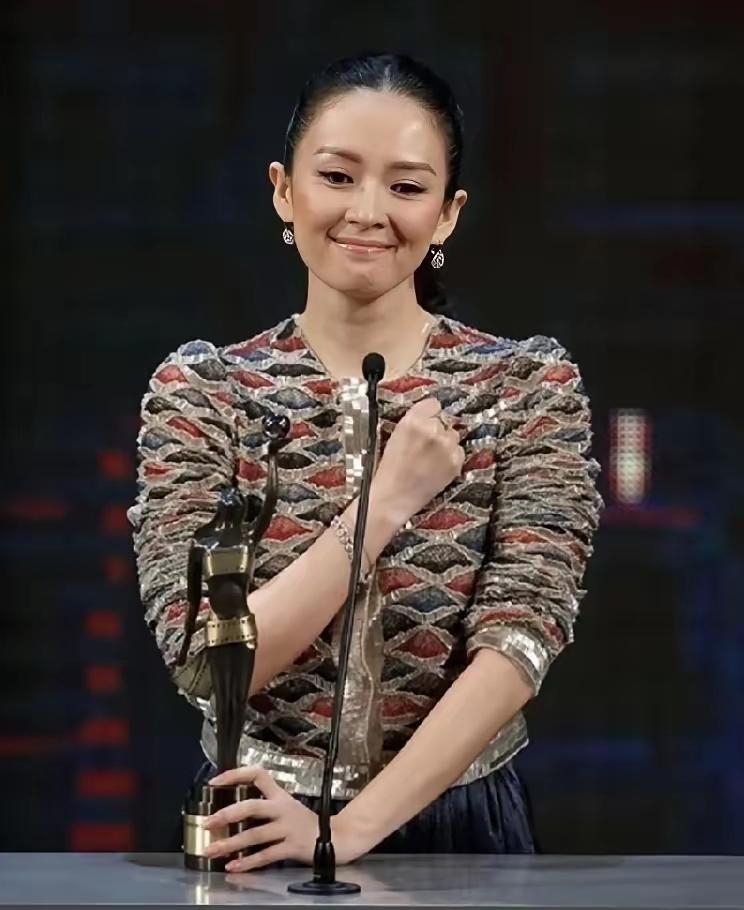 她站在领奖台上，台下坐着张艺谋。全场都在等她感谢恩师，她却说：如果没有张艺谋导演