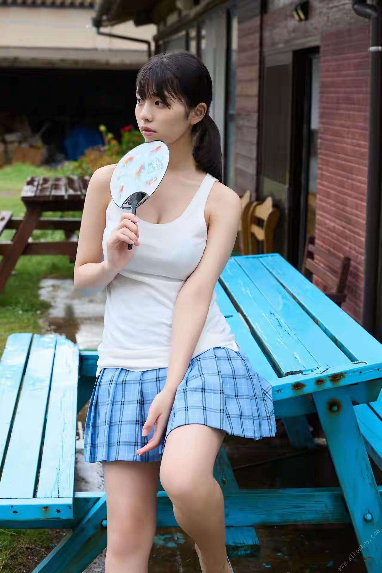 夏日清凉少女，手持扇子，蓝裙飘逸，静坐长椅，享受微风。阳光白裙少女海边白衣少女