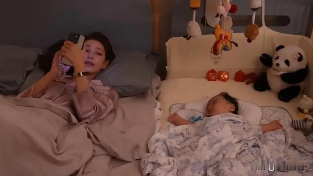 7个月大的汪宝儿躺在妈妈卧室的婴儿床里，举着小手睡得特别香。马筱梅就在旁边玩手