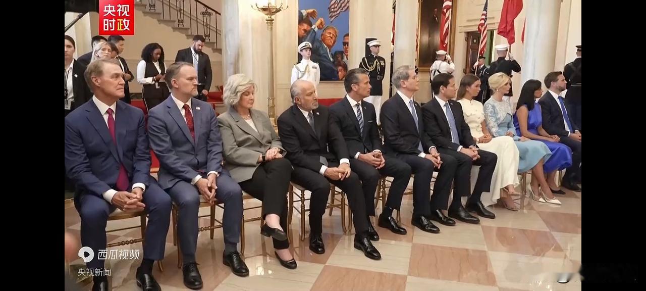 欢迎仪式晚会现场非常安静，美国人排成一排坐着认真聆听，从左到右的分别是：1、伯