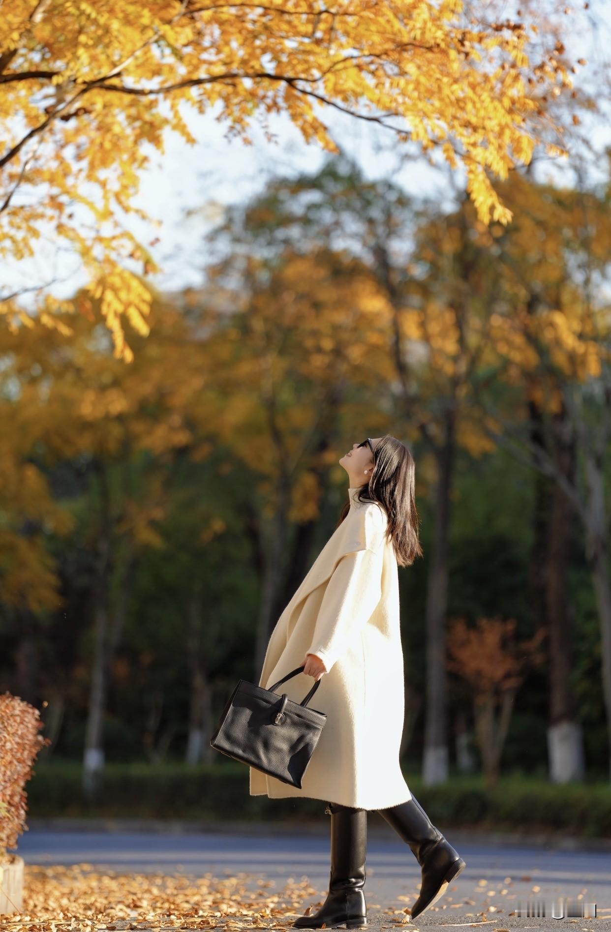 女人怎样穿搭，更显气质秋日漫步，米白色大衣和长筒靴的完美结合！落叶铺满小径，温柔