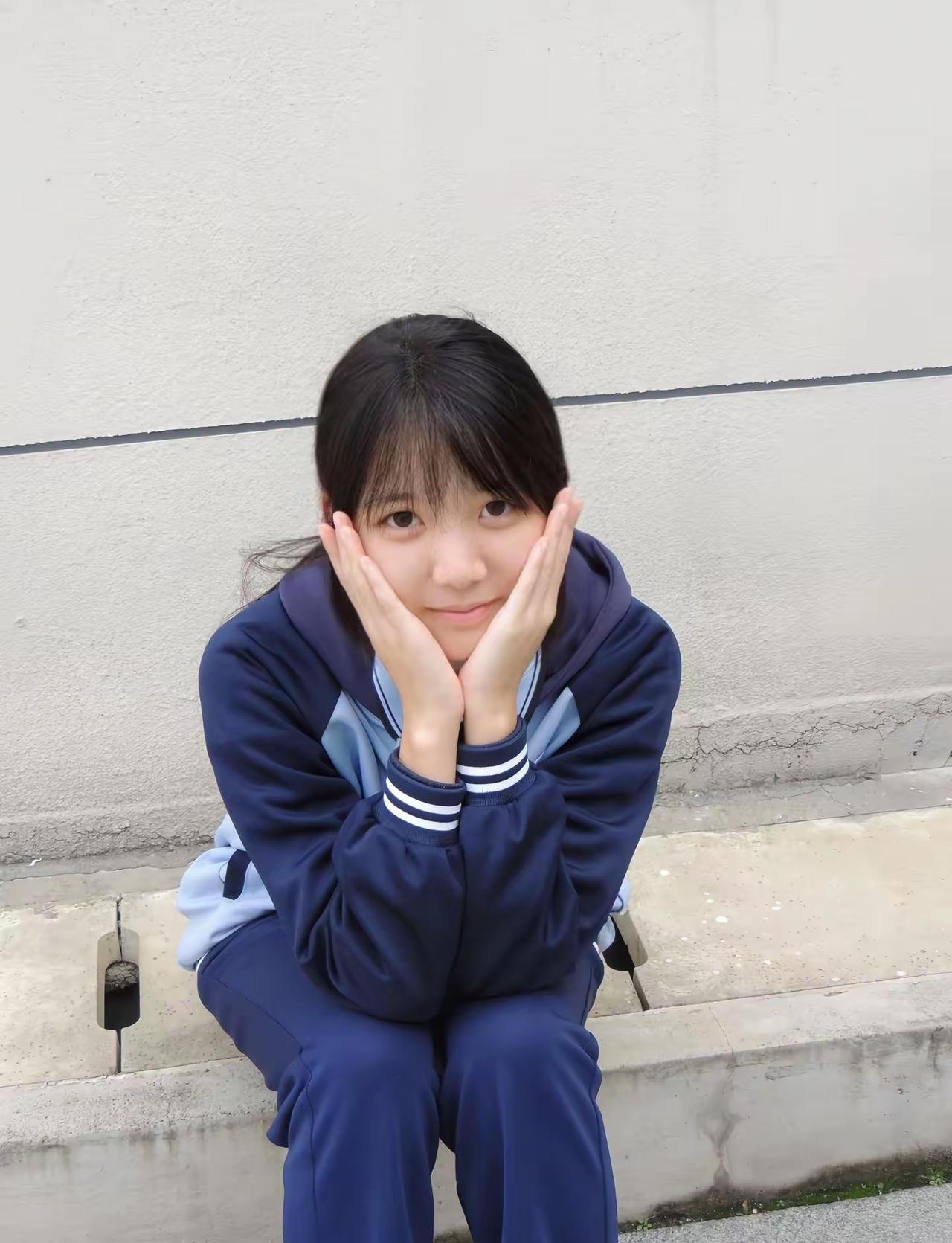 这姑娘坐那墙边，手托着脸笑呢。小姑娘微笑仰头舒展之美女侧倚美女