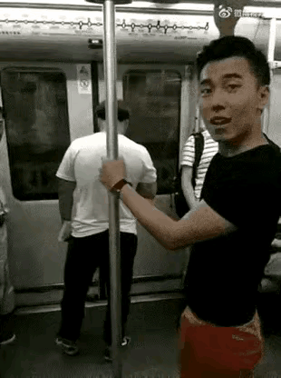 一名中年男人站在地铁门口刷手机，对上上下下的乘客视而不见，极大的阻碍了乘客的出行