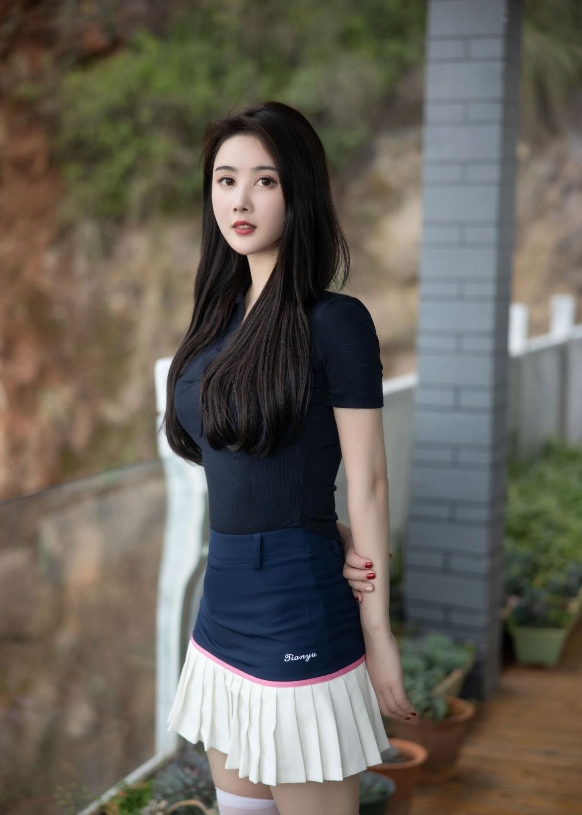 美女穿黑色紧身T恤撞色百褶裙搭配白色过膝长袜小白色好有活力