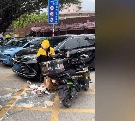 装着32杯奶茶的纸箱“哗啦”一下倒在地上，奶茶杯摔得七零八落，液体混着珍珠、椰果