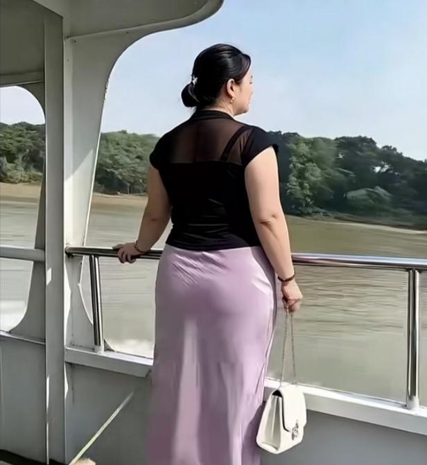 〔在游船之上〕佳人独坐轻舟，悠然观赏江东风光。江水潺潺东流，碧