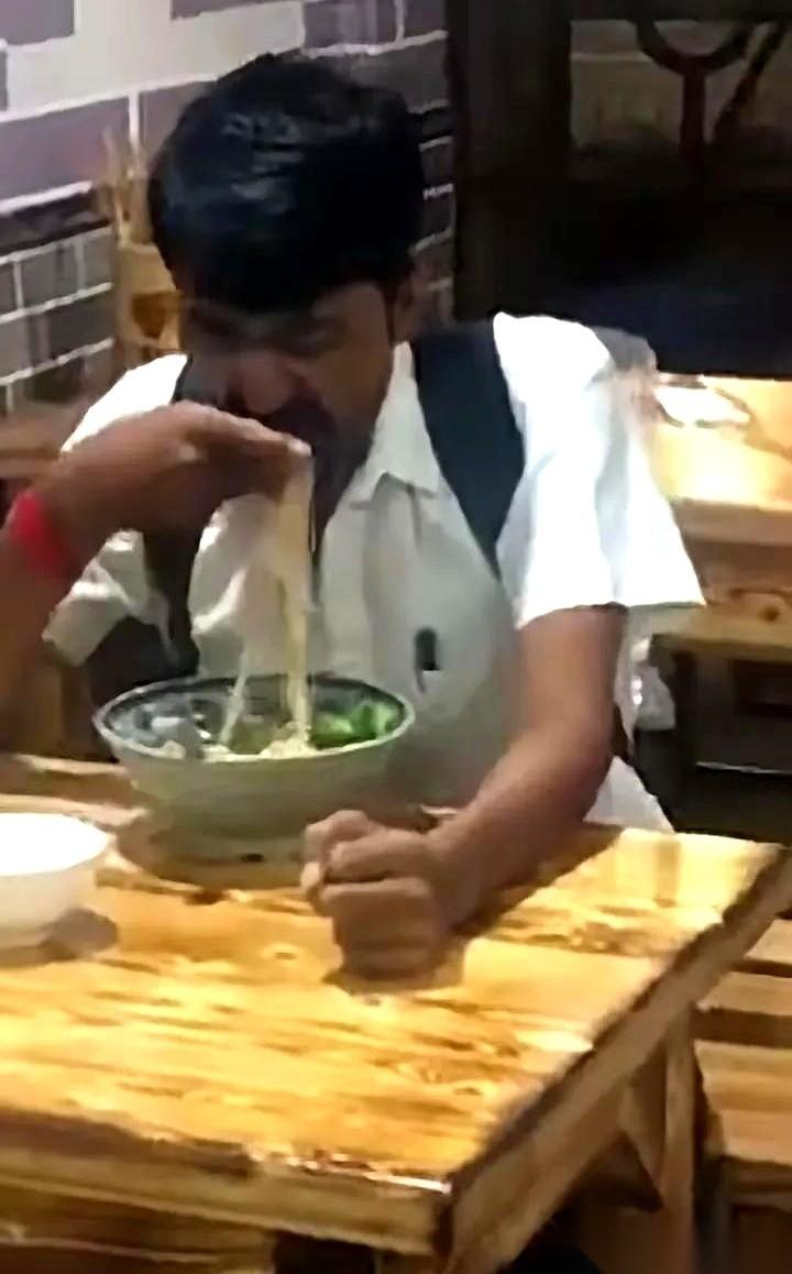 哥们儿,面刚出锅,滚烫滚烫的,他就直接下手了。一家面馆里,一个印度朋友。筷子