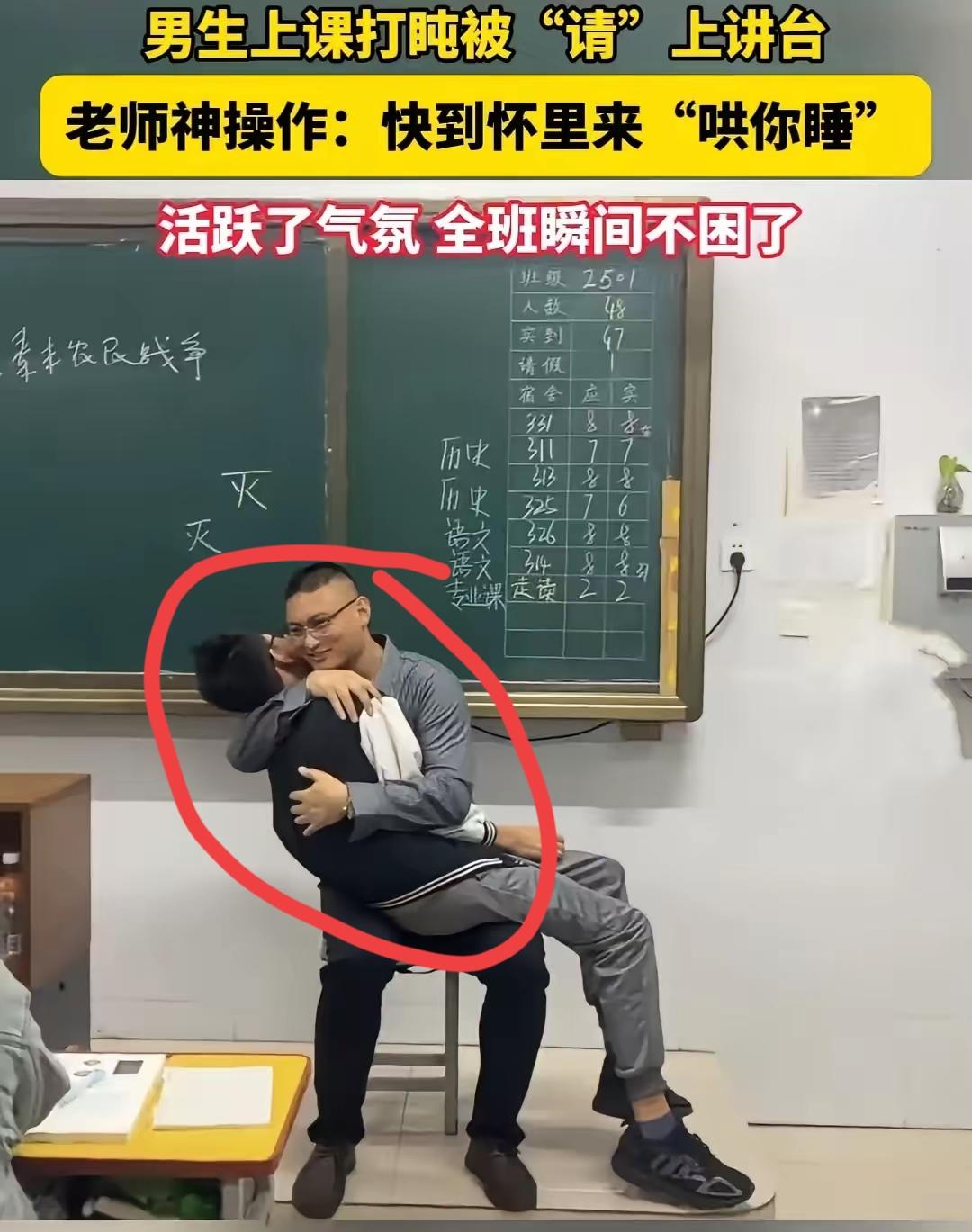 男老师在上课的时候，抱着一个男生在怀里，轻轻拍着哄着他入睡，班上其他的同学看到这