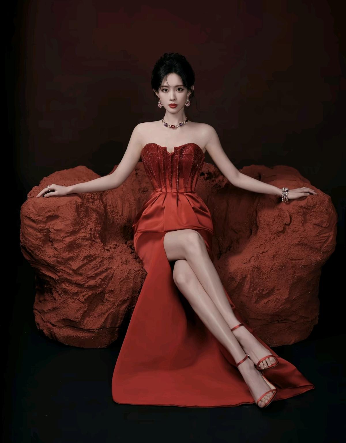 孟子义一袭红裙登场，抹胸束腰勾勒完美线条，高开叉裙摆自带气场，红墙光影间，是明艳