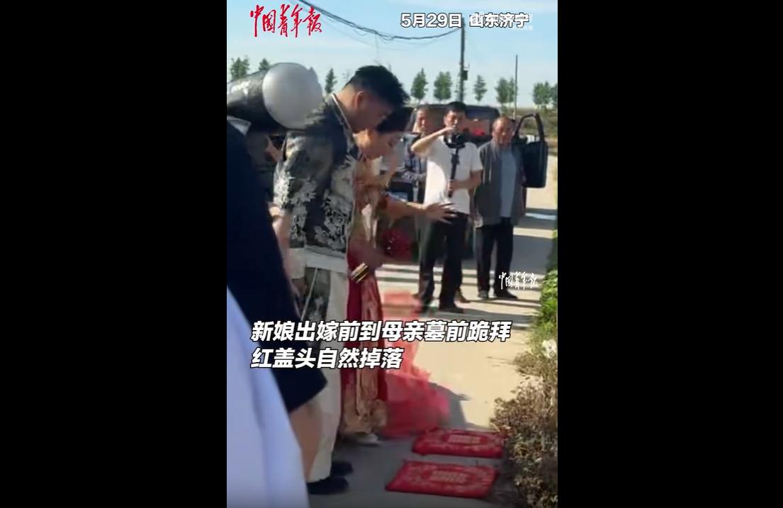 5月29日，山东济宁新娘马女士出嫁当天，特意让婚车绕路前往已故母亲墓前跪拜道别。