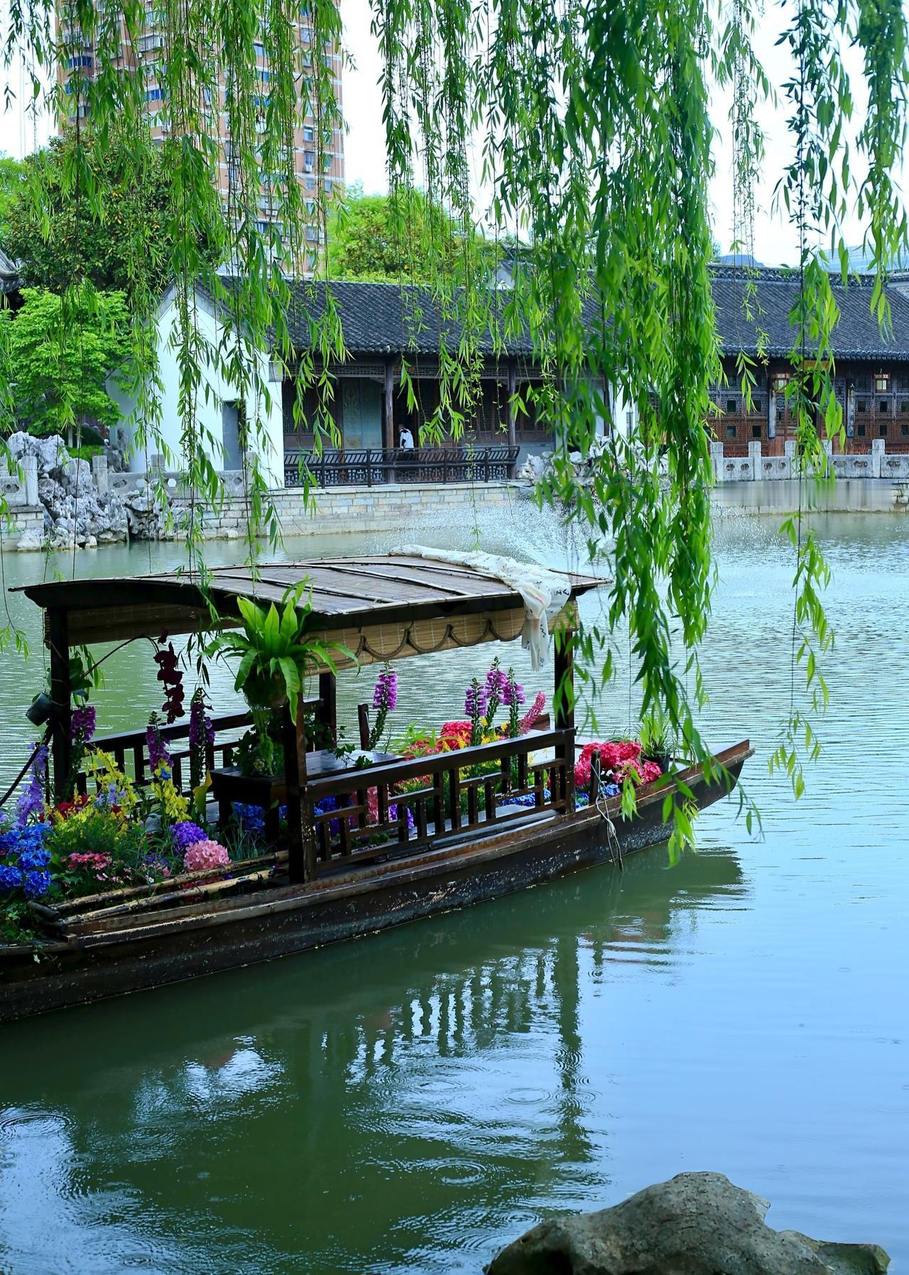 清风拂动岸边绿柳，一叶轻舟泛于澄澈湖面，水光粼粼景致悠然，勾勒出诗意温婉的唯美画