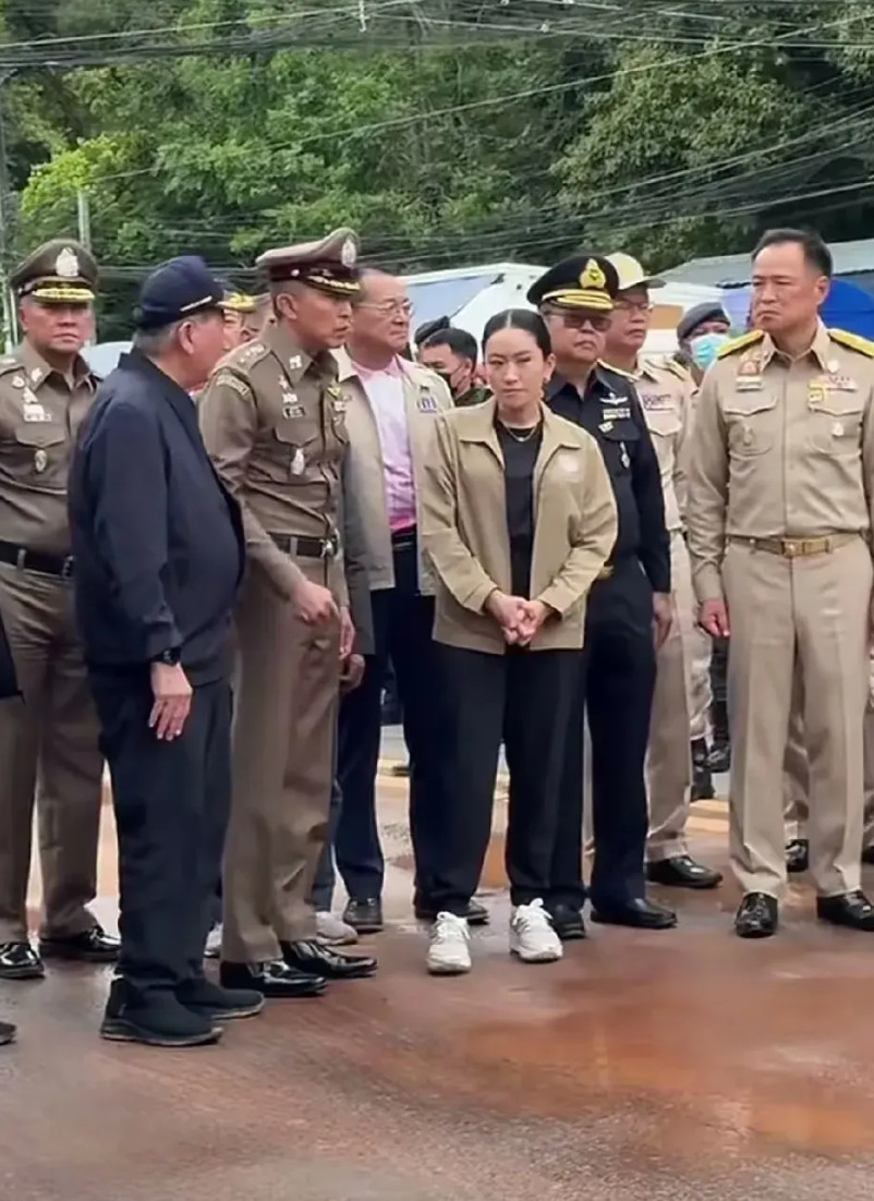 泰国代总理普坦与文化部长佩通坦视察边境士兵。佩通坦被一堆人围着，她在中心出谋
