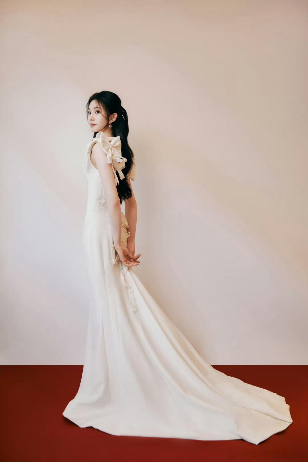 刘浩存刘浩存纯白露背纱裙搭配高颅顶半扎发，优雅灵动，头包脸造型尽显精致气质。