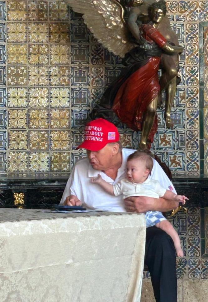 特朗普一手抱着外孙，一手处理工作！特朗普一手抱着外孙亚历山大·特朗普·布洛斯