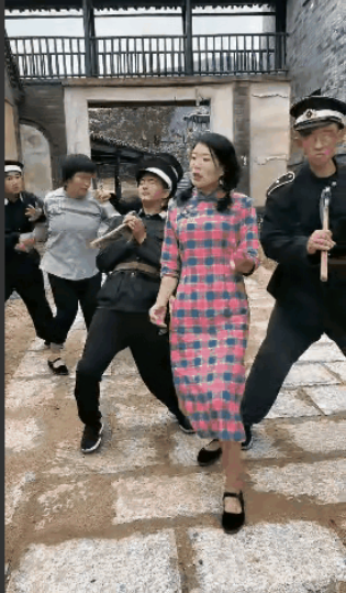 一个地下女游击队员发现她的同事，被叛徒告密了，被伪军抓了起来，伪军压着被抓的游