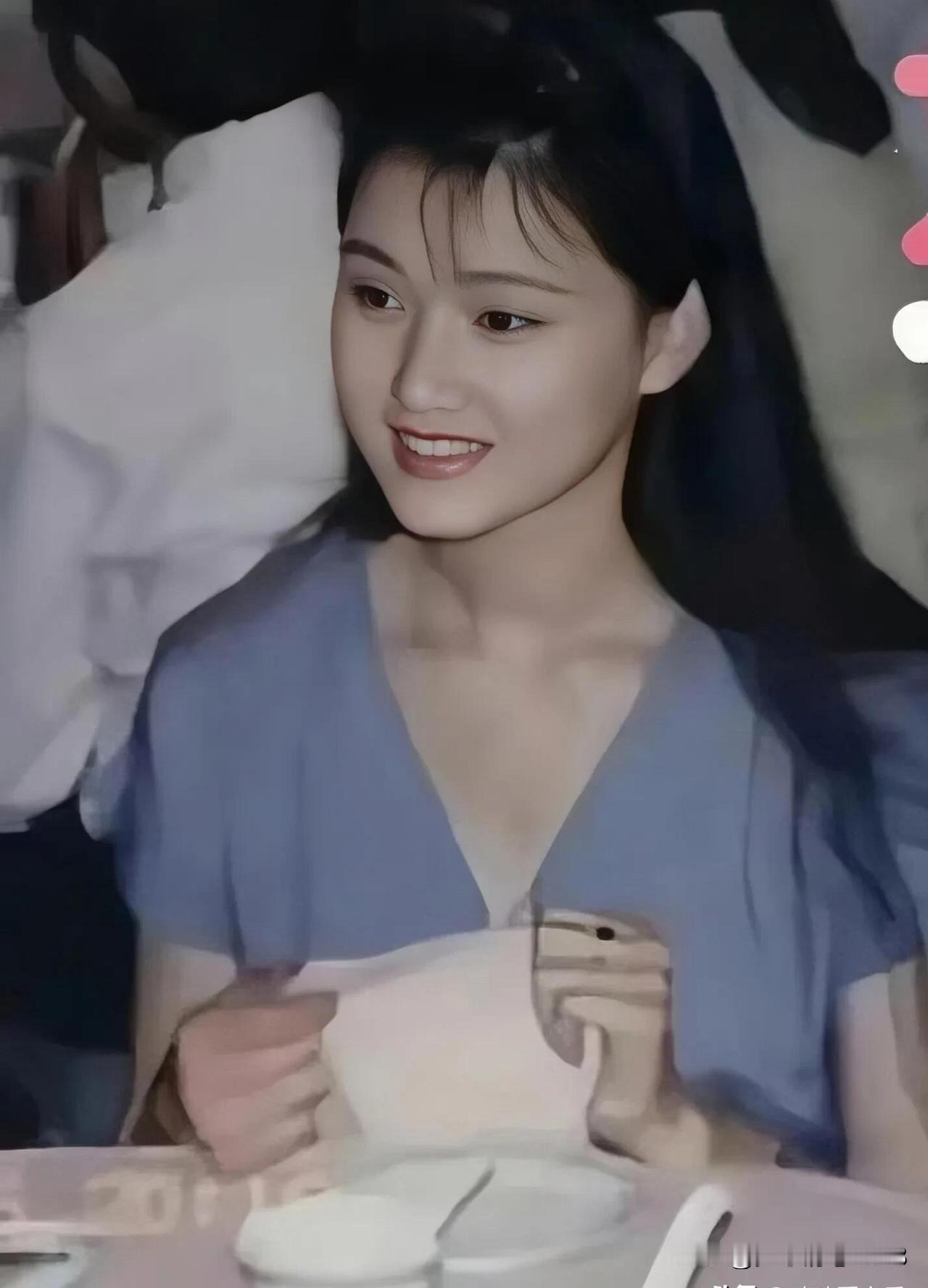 这是90年代最美的一个女歌唱家，柳叶眉樱桃嘴，穿深V设计的连衣裙，气质优雅，温婉