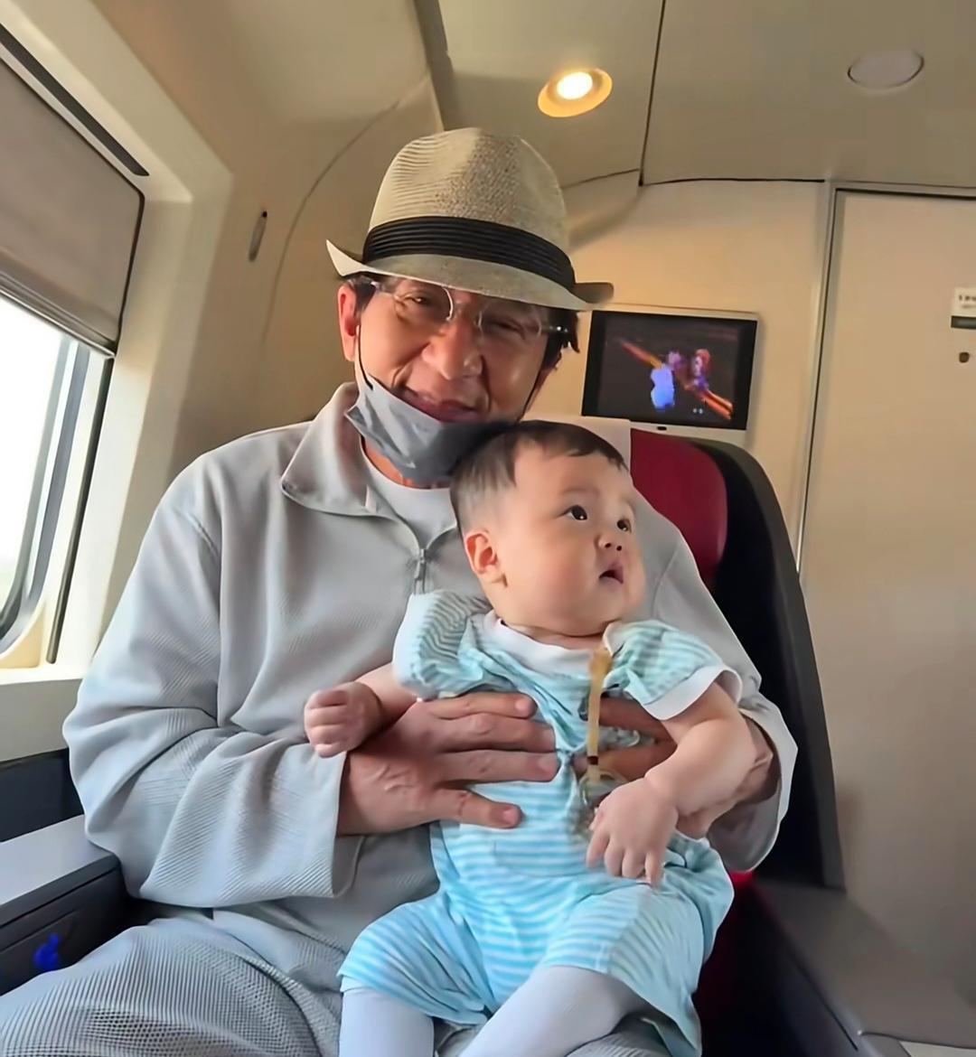 成龙在高铁上被偶遇，他虽然70岁了，但看起来很年轻，和民众们合照，非常的亲民！