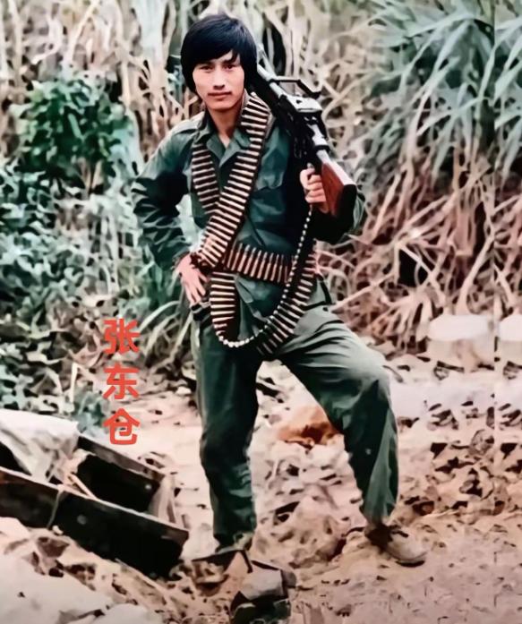 这位身材瘦小、肩上扛着机枪、身上挂满子弹的战士叫张东仓，1962年11月出生，1